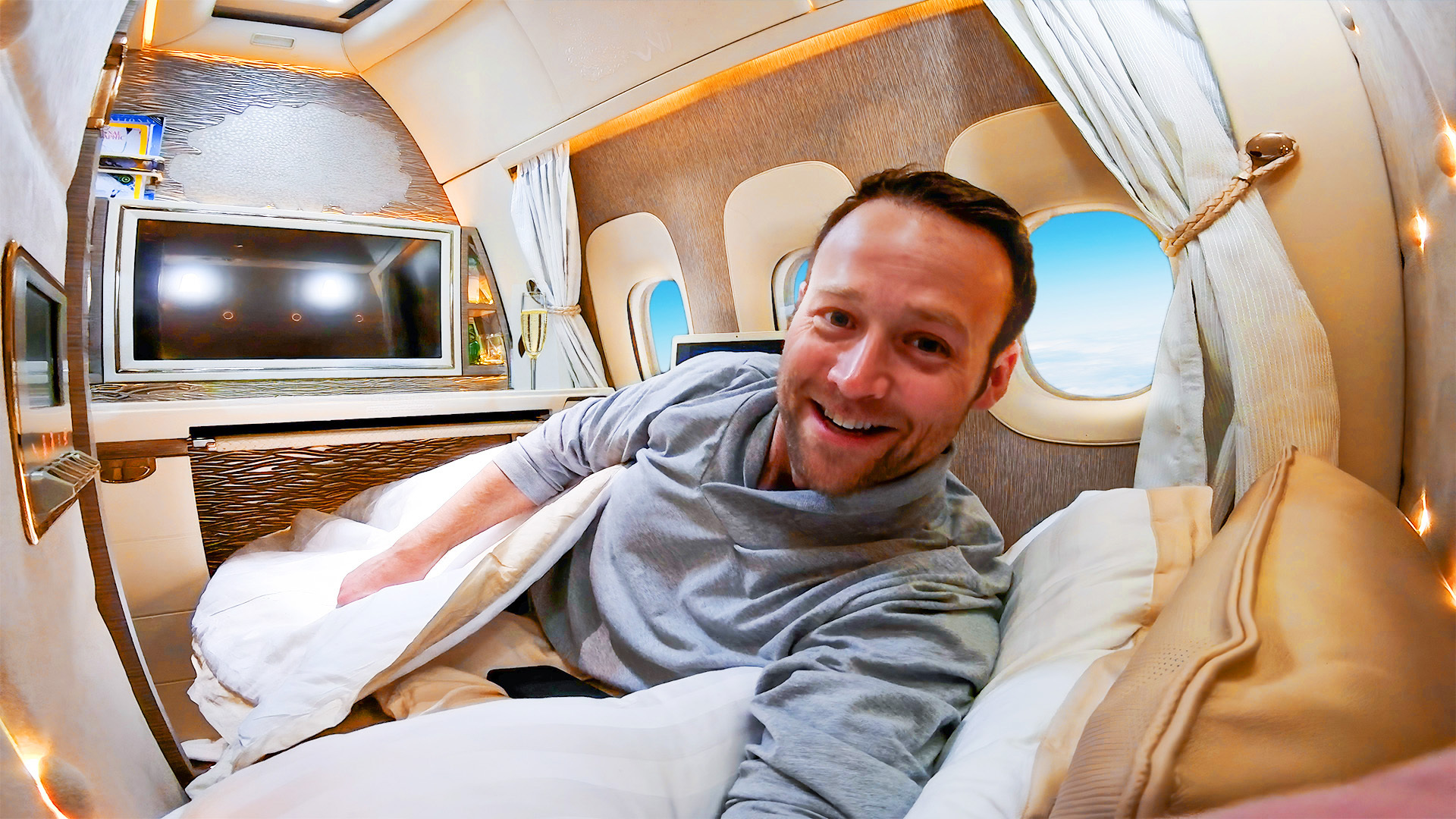 Nik laying in a lie-flat seat in firstclass on an airplane